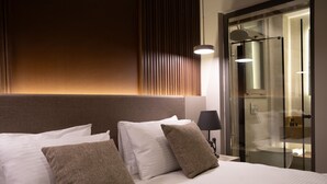 A hotel room with a bed, pillows, a nightstand, a lamp, and a glass shower enclosure. - Monalisa Hotels Çanakkale (Çanakkale)