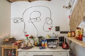 A kitchen with a large wall mural, a coffee machine, and various kitchen appliances. - Il Campanile Salerno (Salerno)