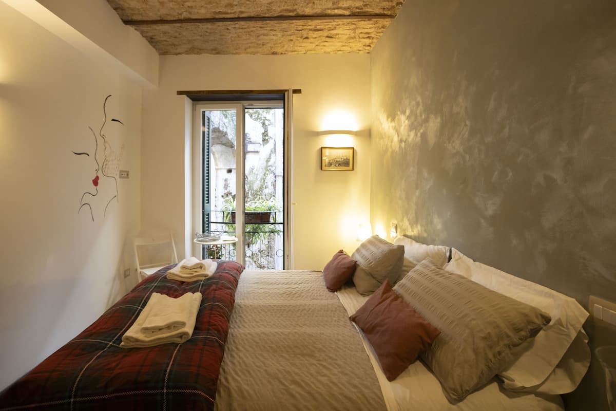 Une chambre à coucher comprenant un lit, un banc, une décoration murale, une porte et une fenêtre.