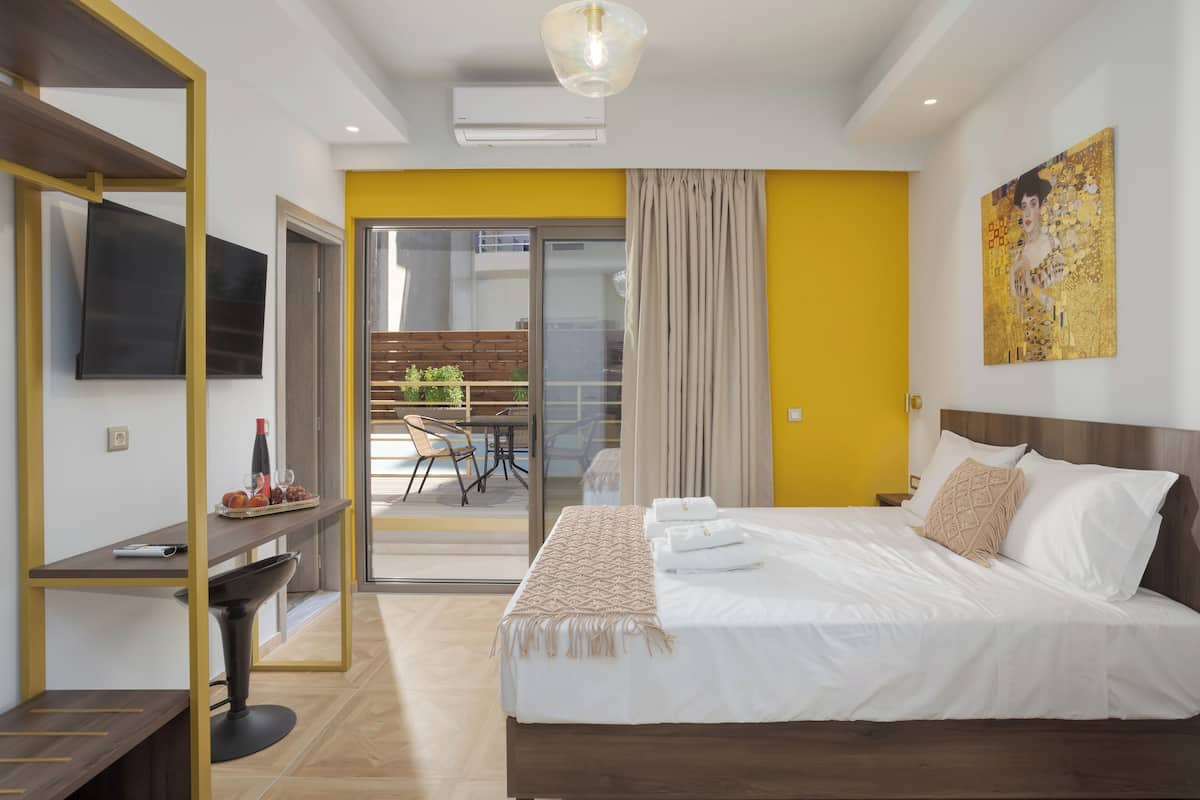 Una habitación de hotel moderna con cama, escritorio y televisor.