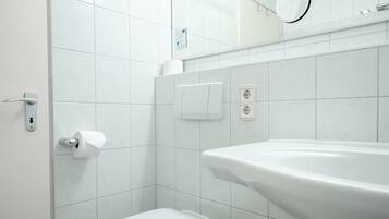 A modern bathroom with a toilet, sink, and mirror.