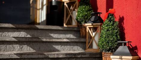 Stone steps leading up to a building with a red exterior wall.