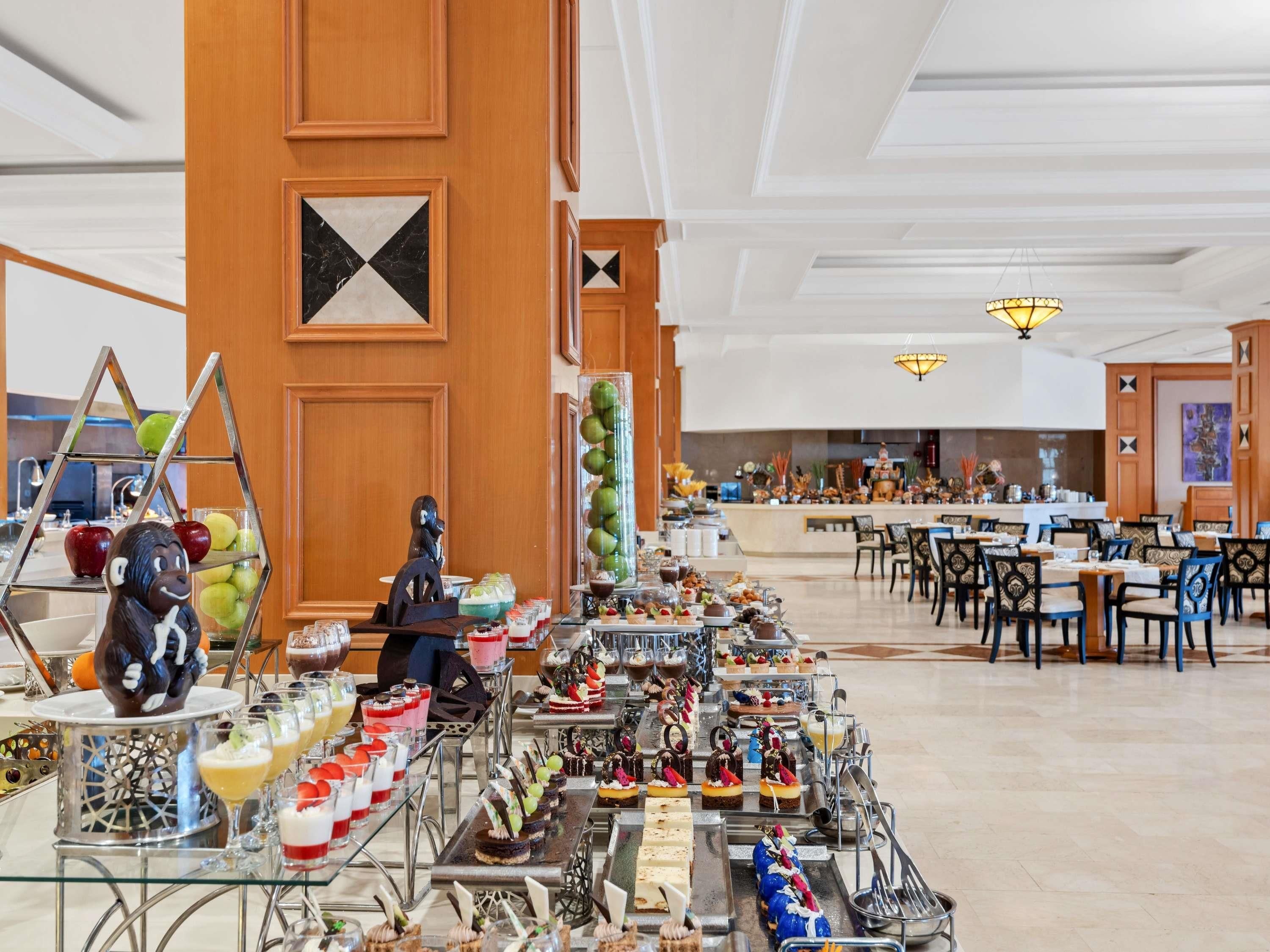 A buffet with various desserts and a monkey statue.