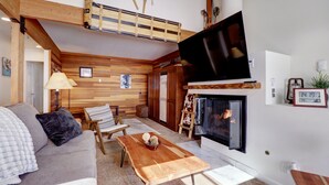 Una sala de estar acogedora con sofá, mesa de centro de madera y chimenea.