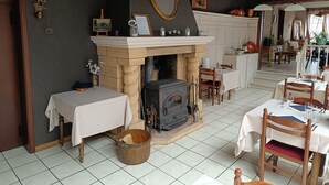 Un comedor tradicional con chimenea, mesas y sillas de madera.