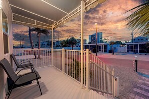 A balcony with a view of a cityscape during sunset.