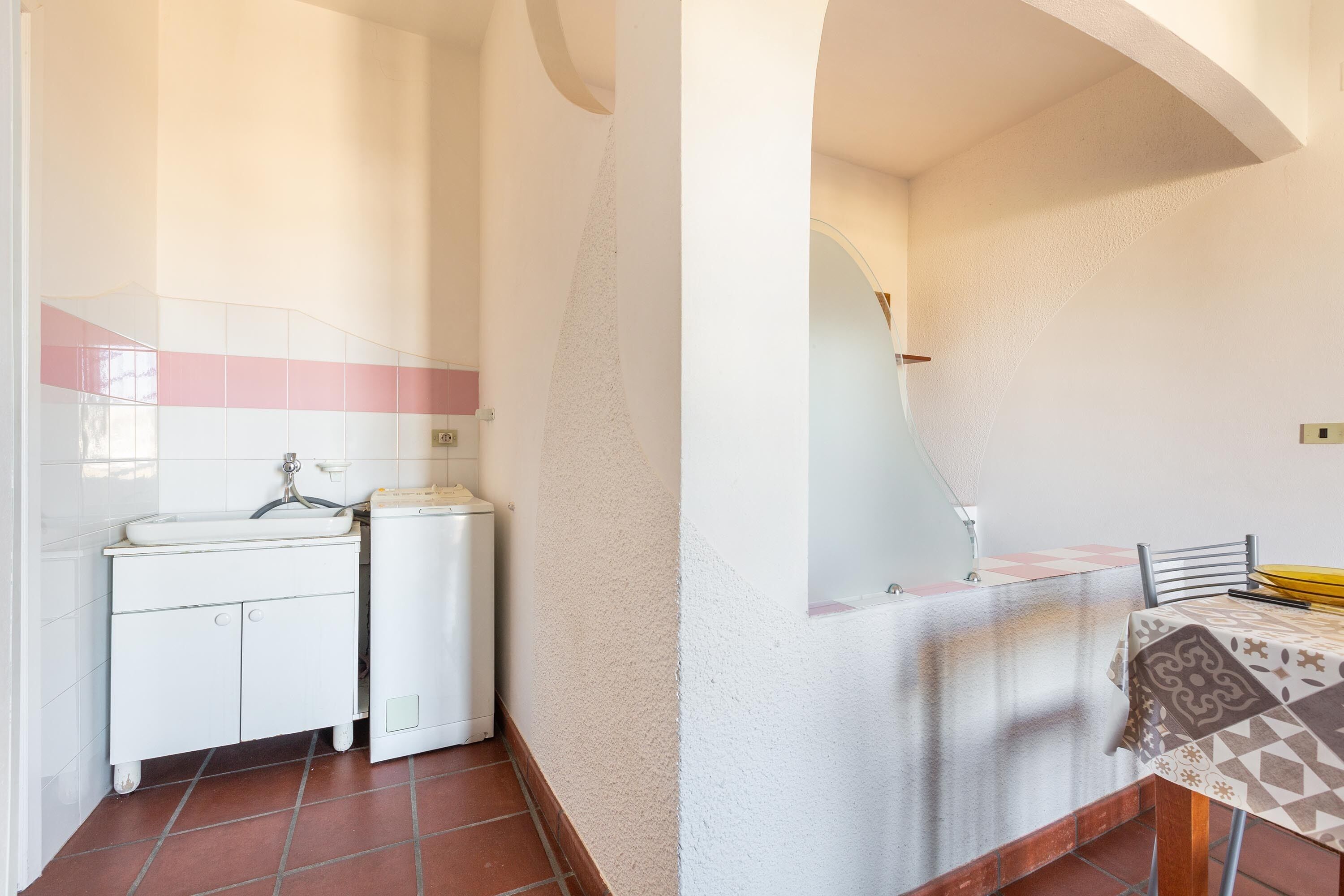 A bathroom with a white sink, a mirror, and a tiled floor.
