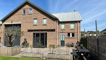 Stunning two-story home with a garage, sliding glass door entrance, and a patio area.