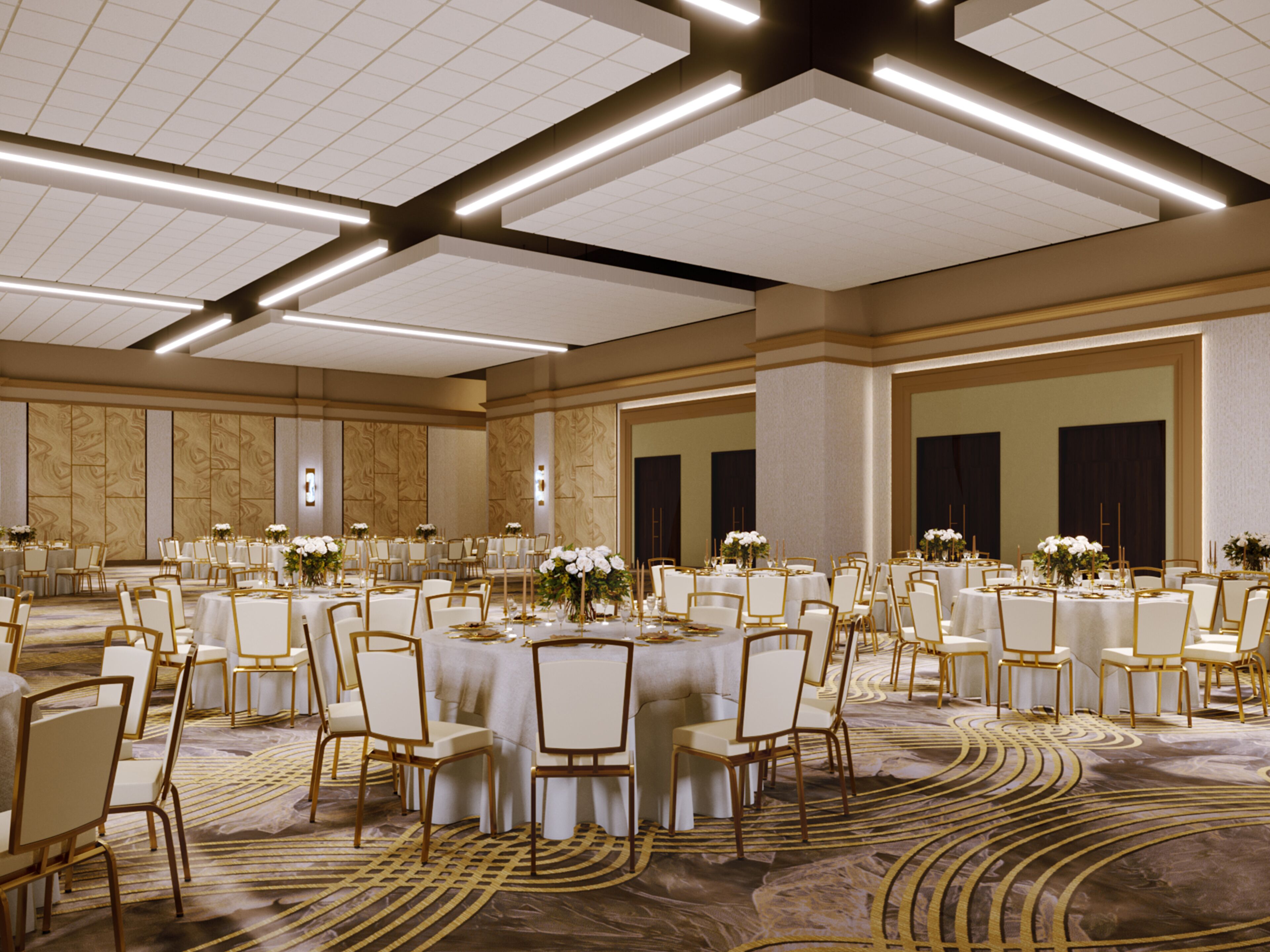 A spacious banquet hall with round tables, white chairs, and floral centerpieces.