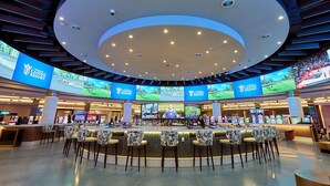 A casino resort with multiple gaming tables and a central bar area.