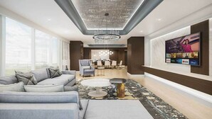 A modern living room with a grey sofa, a round coffee table, and a TV mounted on the wall displaying various streaming services.