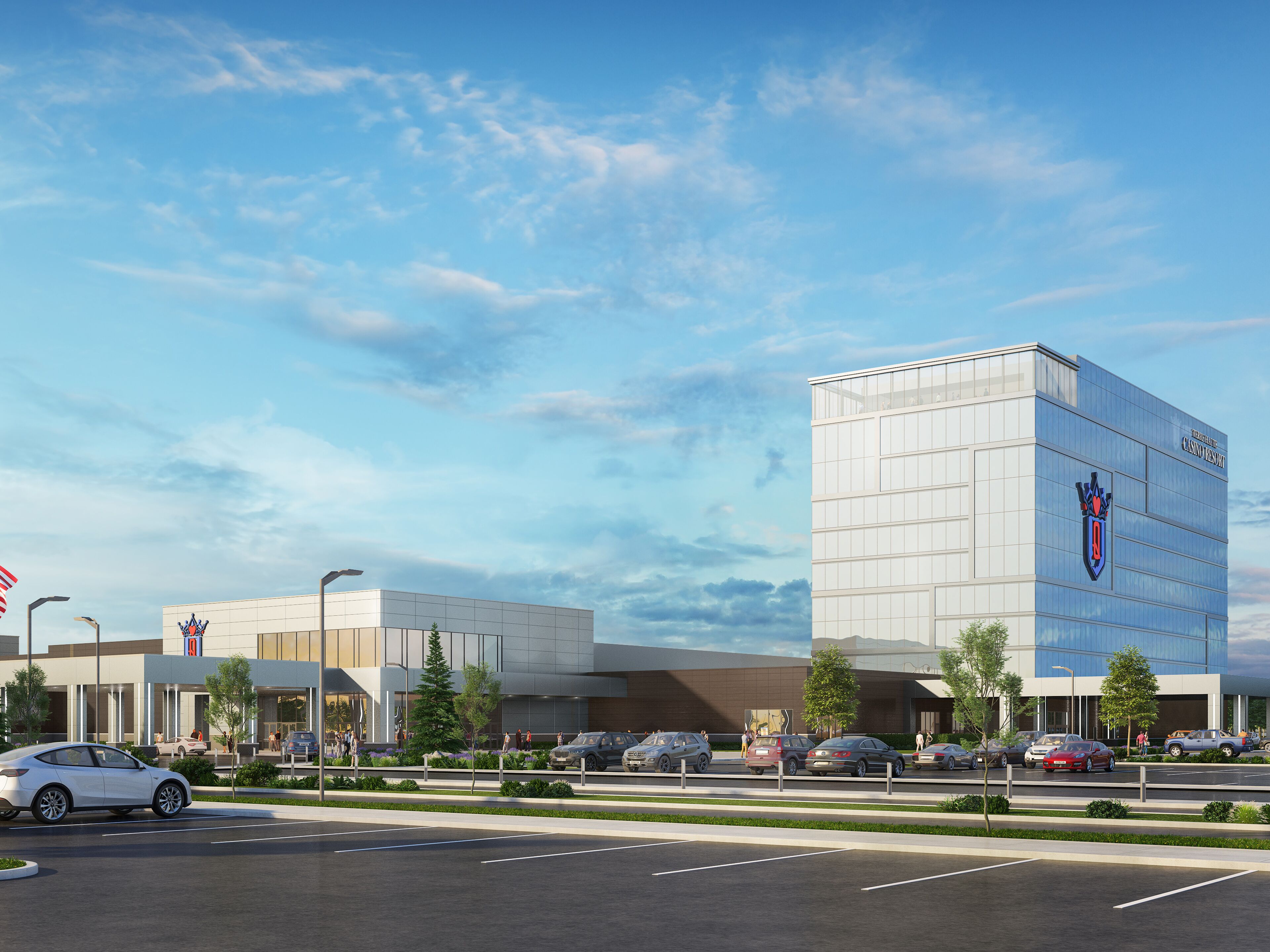 A modern building with a prominent logo on the facade, surrounded by a parking lot with several cars.