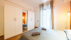 A bedroom with a bed, a wardrobe, and a mirror.