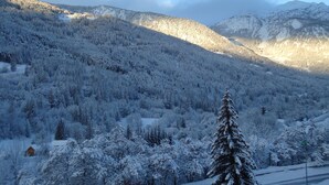 A snow-covered mountain landscape with a dense forest and a clear sky. - SKI IN THE SUN: February 16 to 23, 2025, Serre Chevalier Chantemerle club Maeva (Saint-Chaffrey)