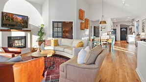 A spacious living room with a fireplace, a sofa set, and a dining area. - Woodhaven on Pleasant Lake |Pleasant Lake |Lakefront |Wraparound Deck |Views |Dock |Kayaks & Boards (East Troy)
