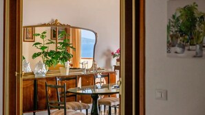 Een eetgedeelte met een ronde tafel, stoelen en een grote spiegel die de kamer weerspiegelt.