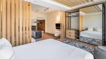 A modern bedroom with a large bed, a desk, and a wardrobe.