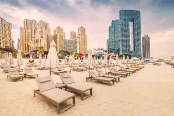 Relax on the beach with a view of the city skyline from our sun loungers.