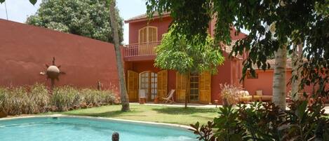 Alberca al aire libre, sombrillas en la alberca y camastros