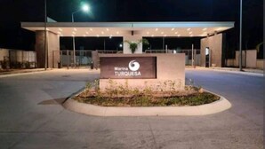 Señal de Marina Turquesa frente a un edificio moderno de noche.