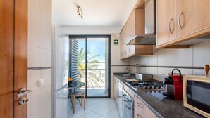 A modern kitchen with a gas stove, microwave, and cabinets.