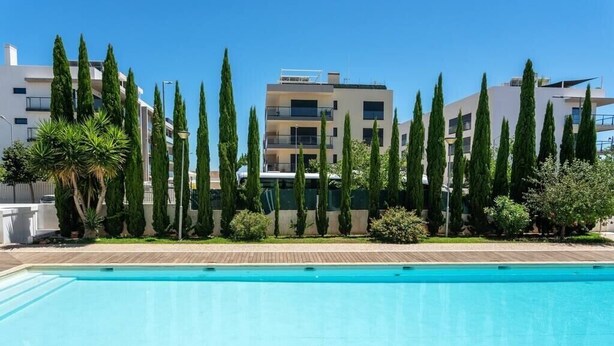 A swimming pool with a modern building in the background.