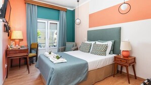 Habitación de hotel con cama, escritorio, silla, mesita de noche y ventana con cortinas.