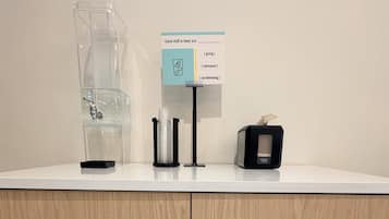 A counter with a coffee machine, a water dispenser, and a tissue box.