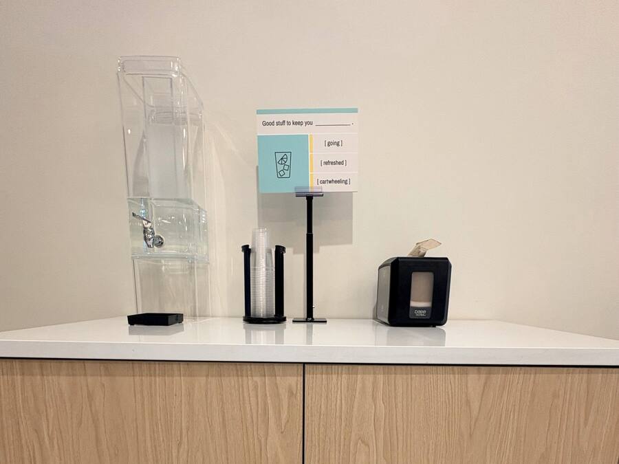 A counter with a coffee machine, a water dispenser, and a tissue box.