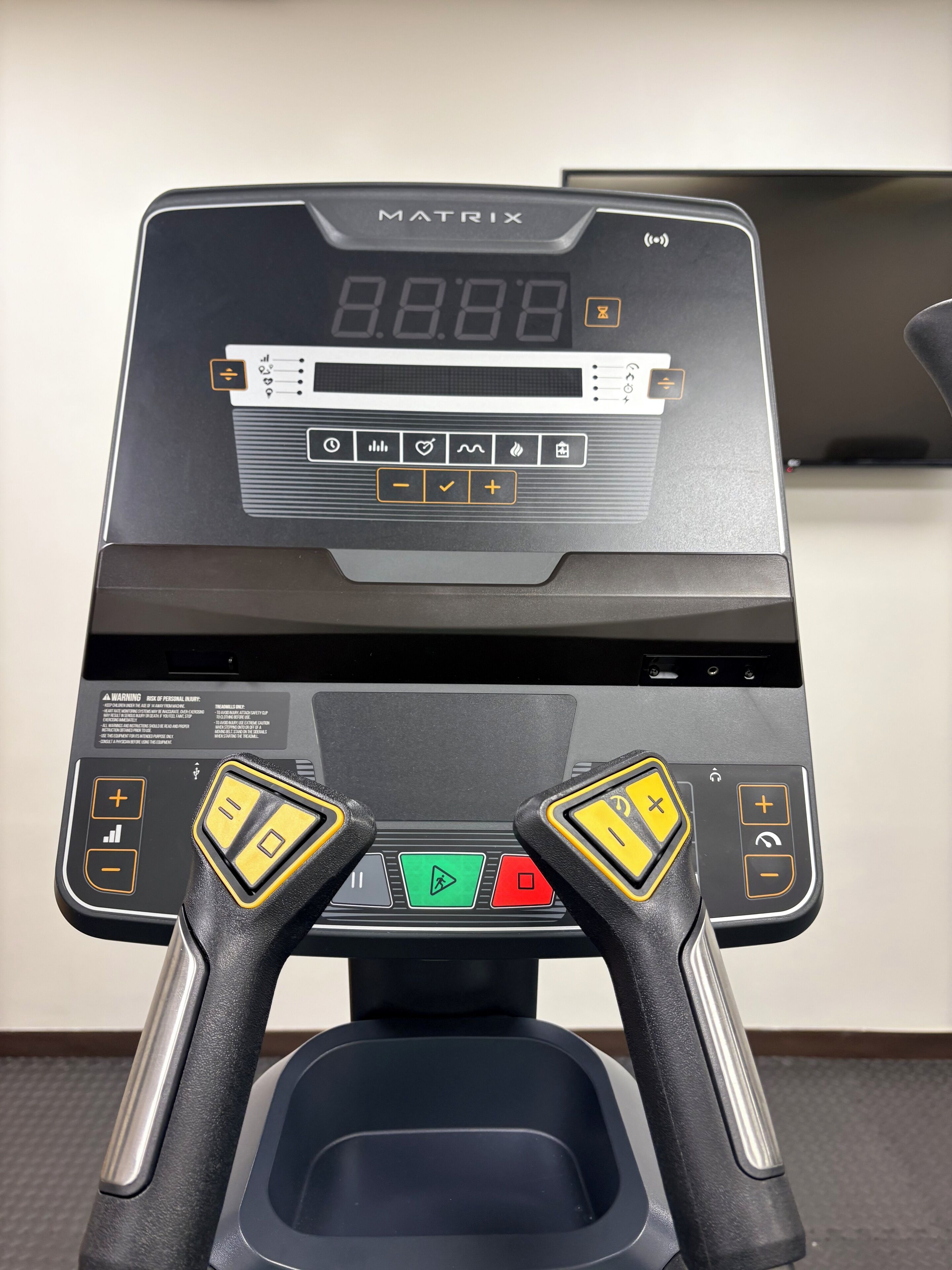 Una cinta de correr con pantalla digital, botones de control y una llave de seguridad.
