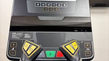Una cinta de correr con pantalla digital, botones de control y una llave de seguridad.