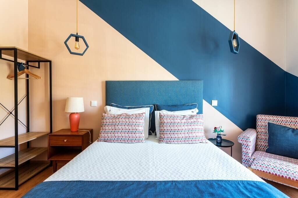 A bedroom with a bed, bedside tables, a dresser, and a chair.
