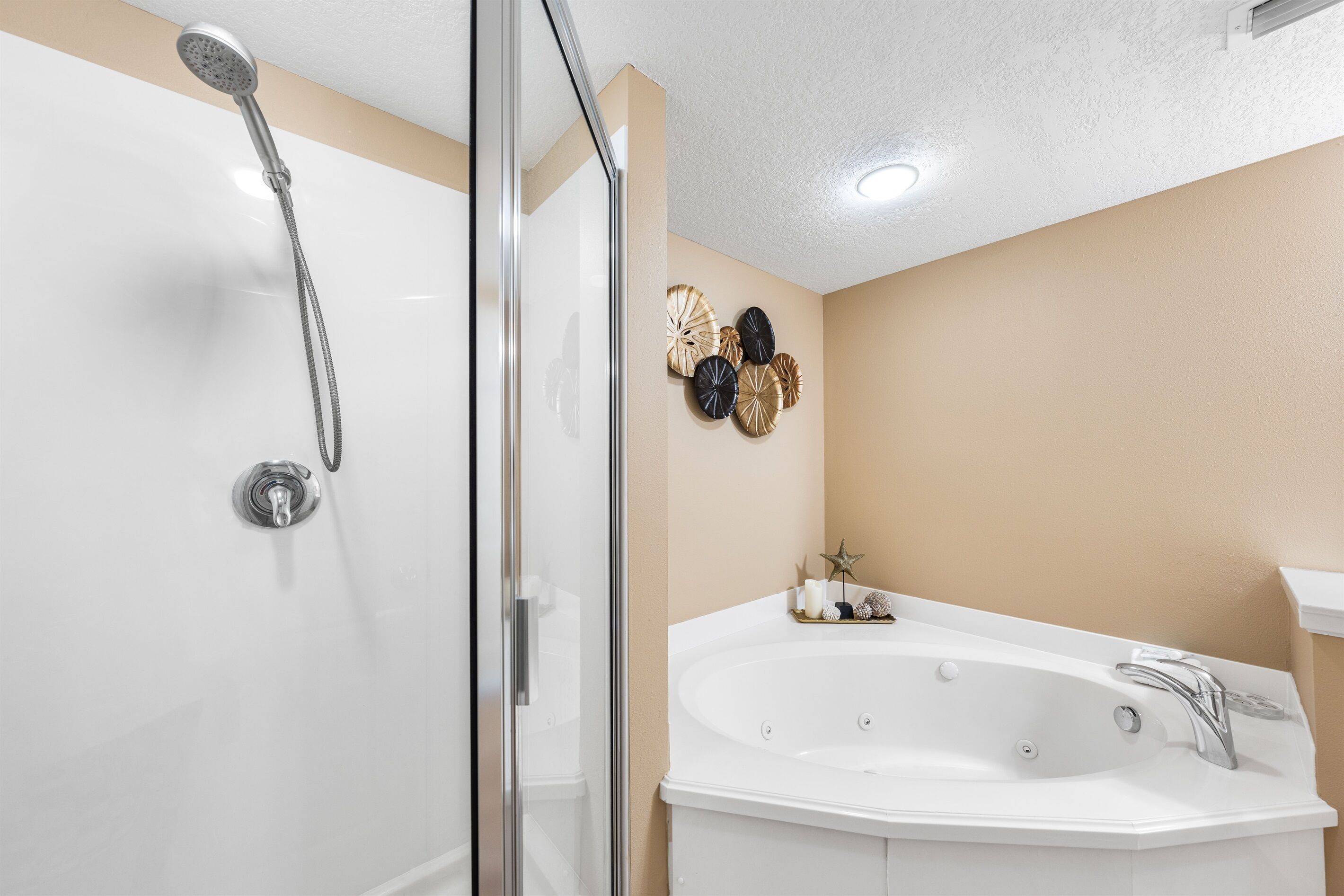 Ein Badezimmer mit Duschkabine, freistehender Badewanne und verzierten Wandplatten.