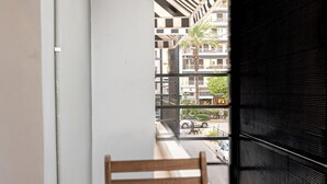 Ein Balkon mit Holztisch, zwei Orangensaftgläsern, einer Auswahl an Gebäck, einer Kaffeetasse und einem Löffel.
