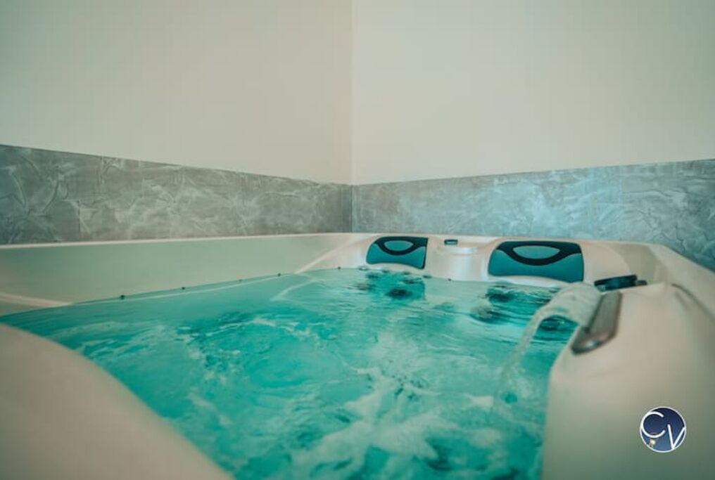 A hot tub with a textured wall and a logo in the corner.