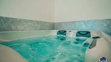 A hot tub with a textured wall and a logo in the corner.