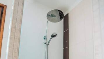 Een douche met een handdouche en een handbedienbare kraan.