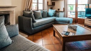 A modern living room with a sectional sofa, a coffee table, and a fireplace. - Maison Avec Piscine, Jacuzzi, Sauna et Billard (Le Thor)