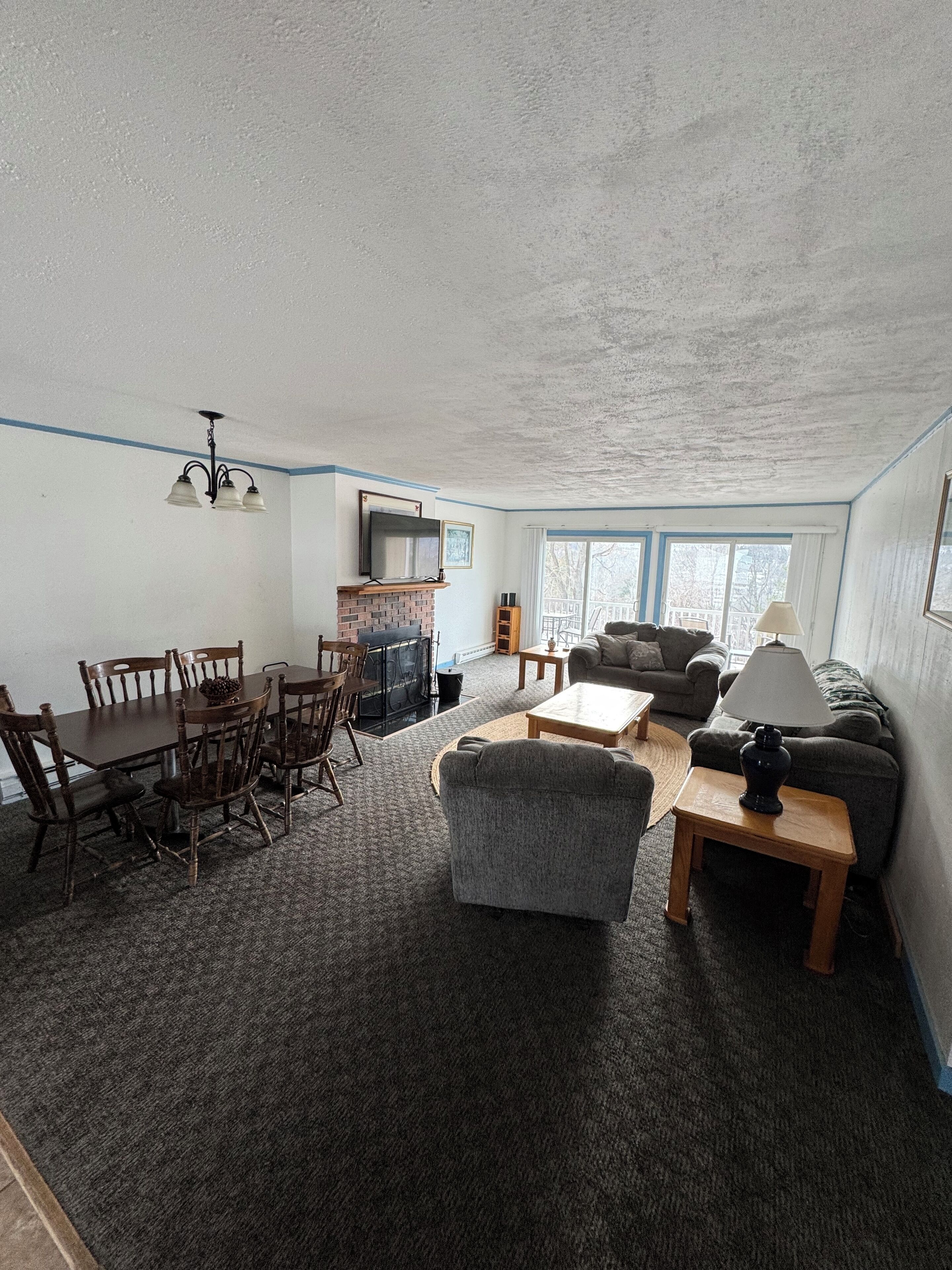 A living room with a dining area, a fireplace, and a television.