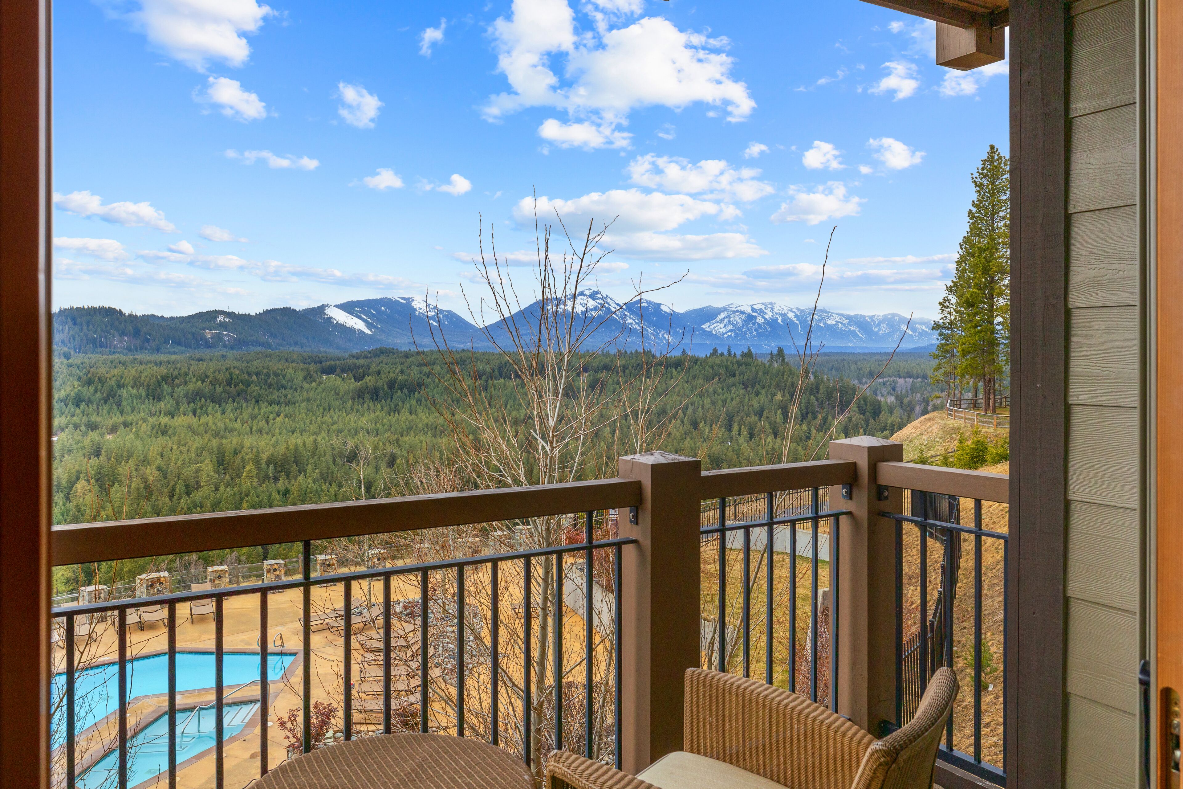 Un balcon avec vue sur une chaîne de montagnes et une piscine.