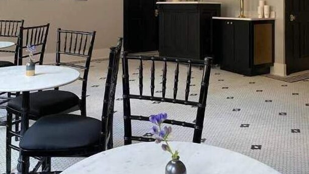 A dining area with round tables and chairs, a black cabinet, and hanging light fixtures. - Ulysses Suites, Suite 201, 2 bedroom/2 bath, full kitchen and living room (Galena)
