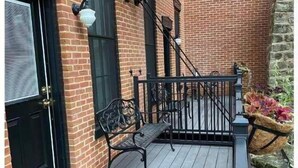 A wooden deck with a bench and a metal railing. - Ulysses Suites, Suite 201, 2 bedroom/2 bath, full kitchen and living room (Galena)