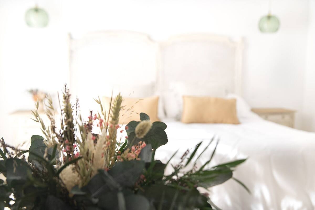 Une chambre à coucher avec un lit, des oreillers et une table de chevet.