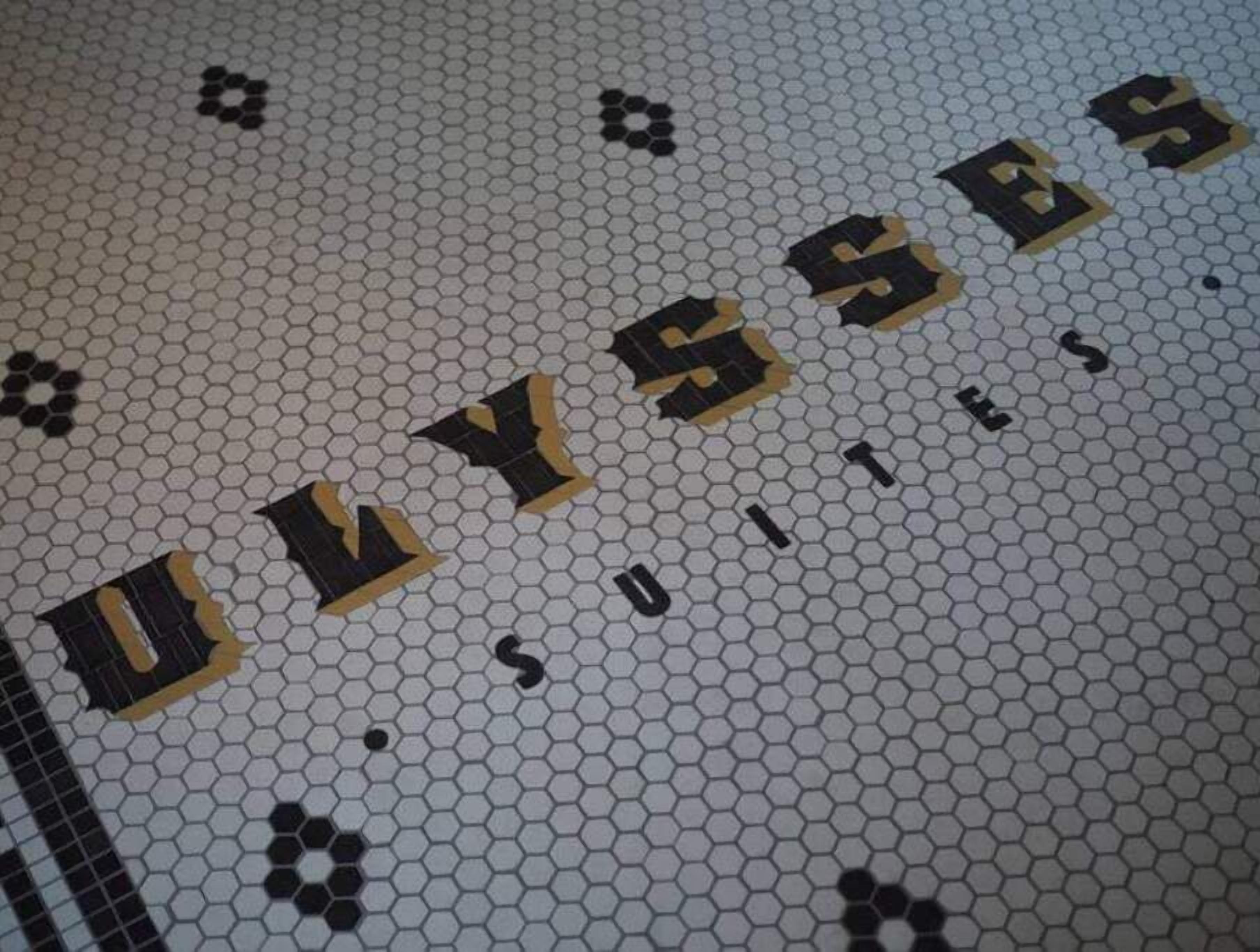Un sol carrelé sur lequel le mot « ULYSSE » est inscrit en grandes lettres.