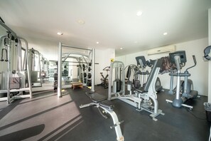 A gym with various exercise machines, a bench, and a mirrored wall. - ANAH - Central Condo - 2 Bedrooms (Playa del Carmen)