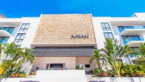 A modern building with a stone facade and the name "ANAH" on the front. - ANAH - Central Condo - 2 Bedrooms (Playa del Carmen)