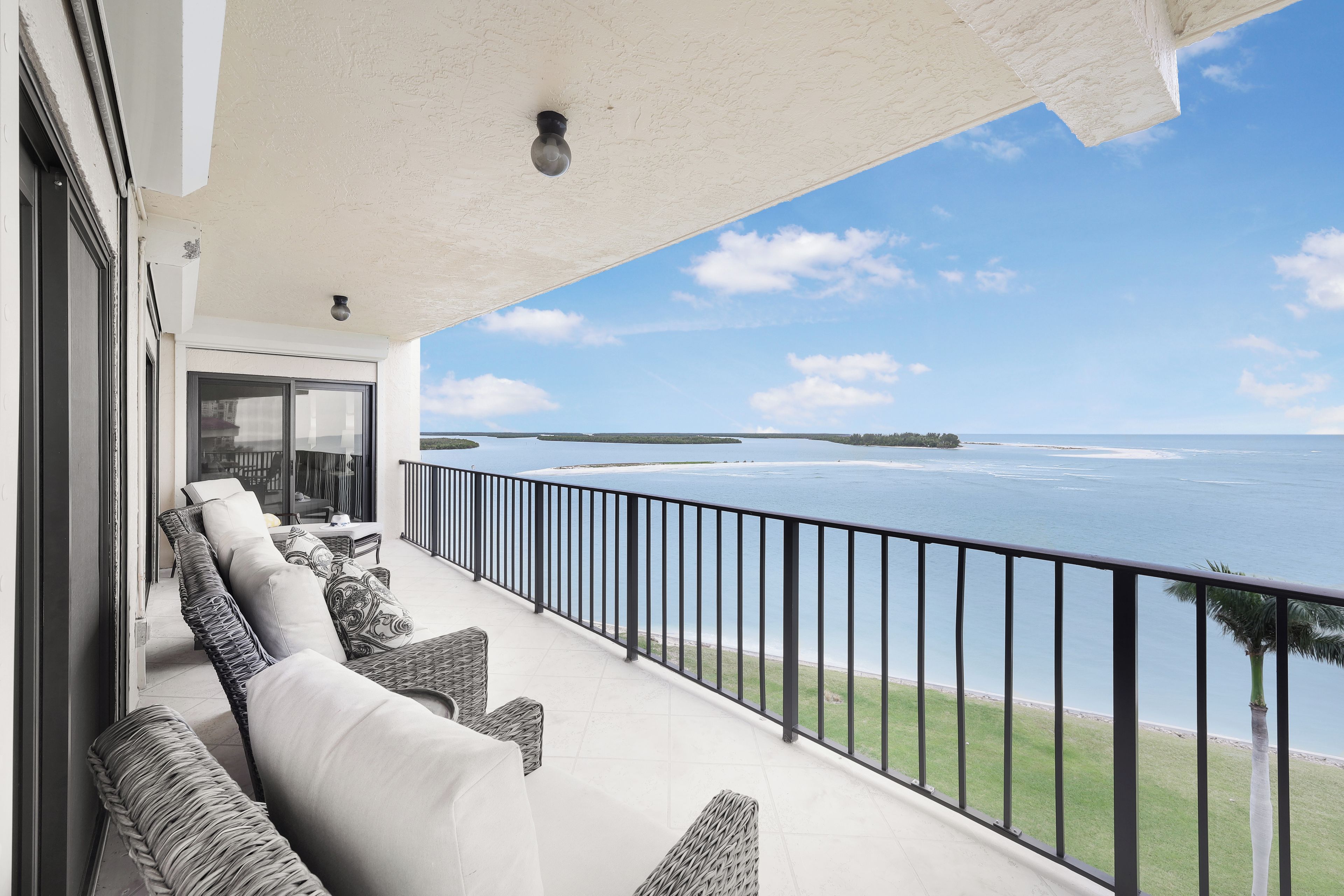 A balcony with outdoor furniture overlooking a body of water.