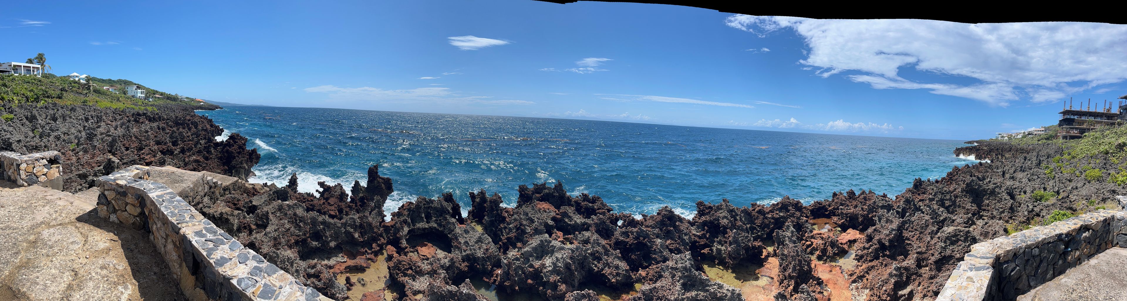 A coastal landscape with rocky terrain and a view of the ocean.