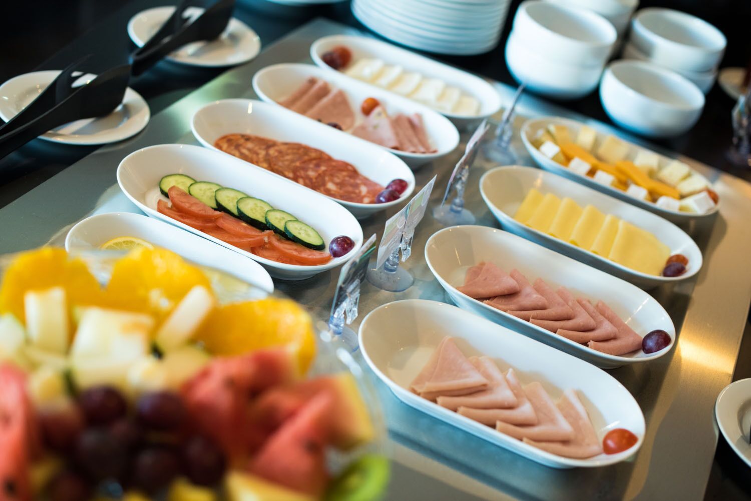 Een buffet met diverse soorten eten, zoals fruit, kazen en vlees.