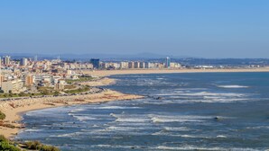 Un paysage urbain côtier avec une plage, des bâtiments et un ciel dégagé.